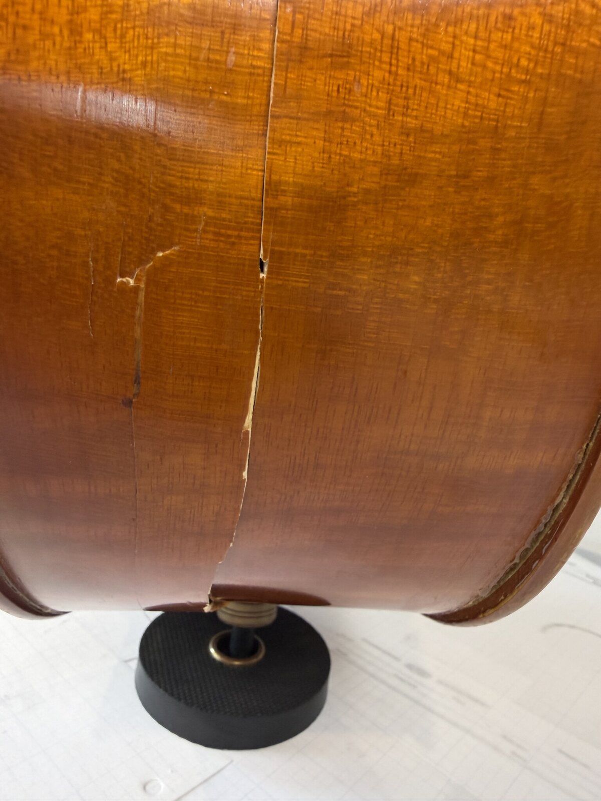 Open structural crack and joint separation in the cello rib at the bottom block, running down to the endpin