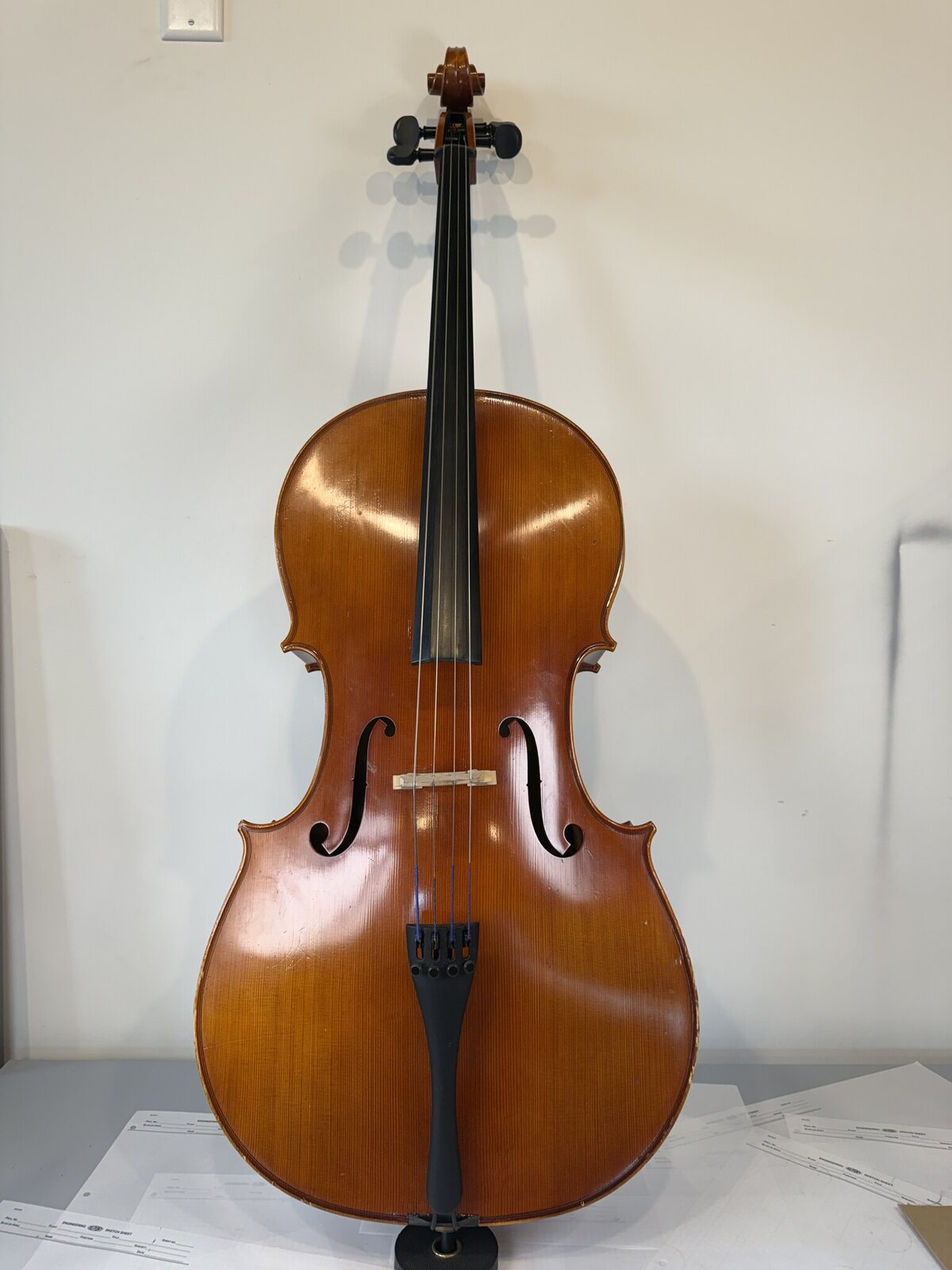 Front of the Otto Benjamin cello photographed before setup, with the bridge lying flat on the top